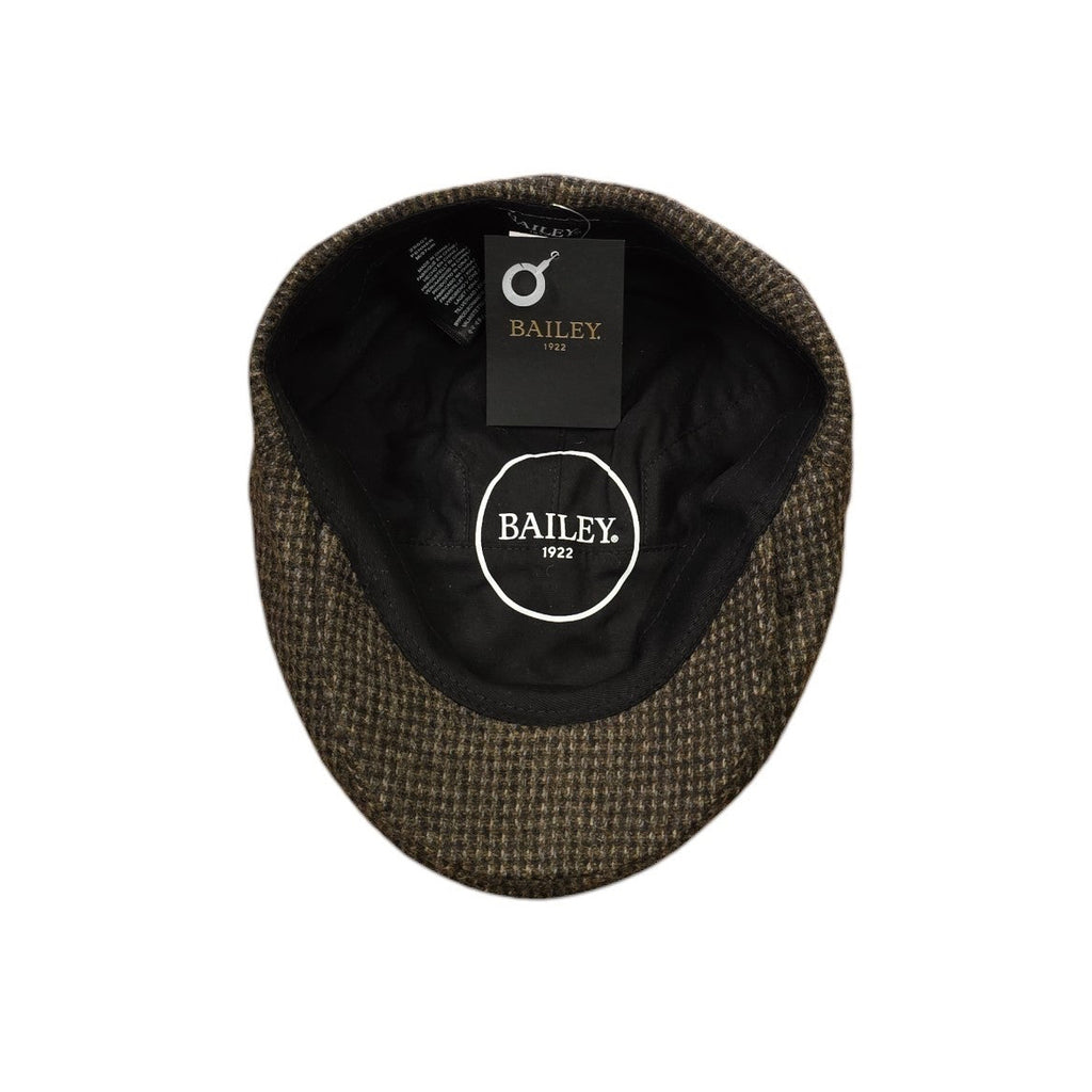 A top-down view of a Bailey 19122 Penner Duckbill cap, showing its dark brown and black textured tweed exterior and black interior lining with a circular logo patch.